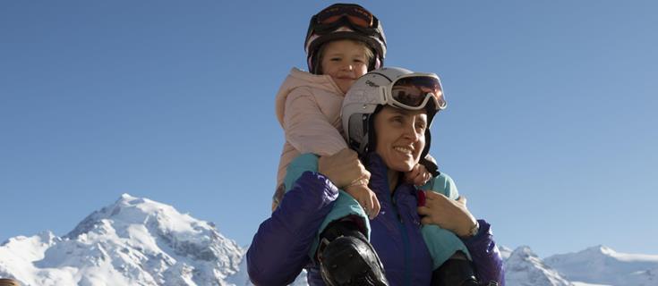 Una donna porta una bambina sulle spalle